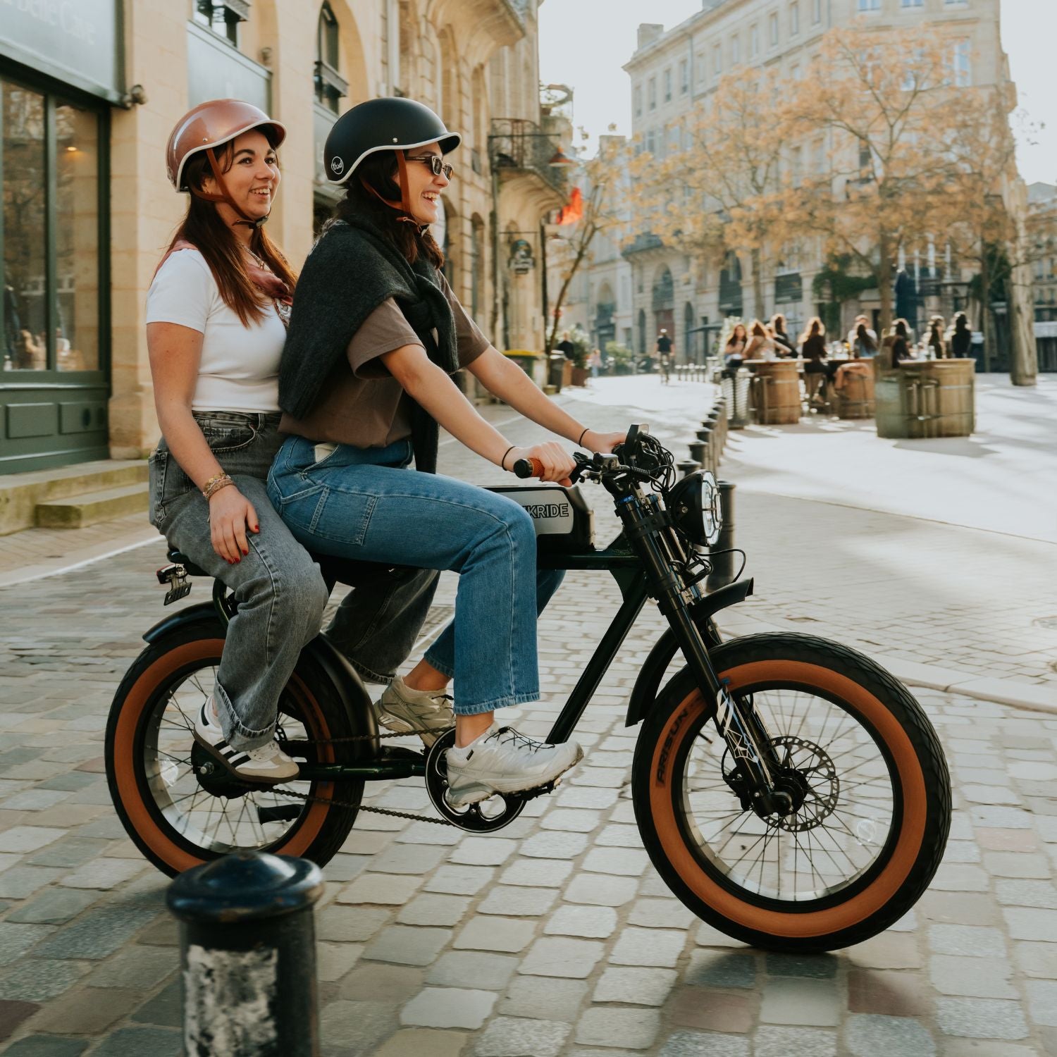 Fatbike électrique 2 places City S avec phare LED allumé dans une rue pavée, vélo électrique biplace urbain.