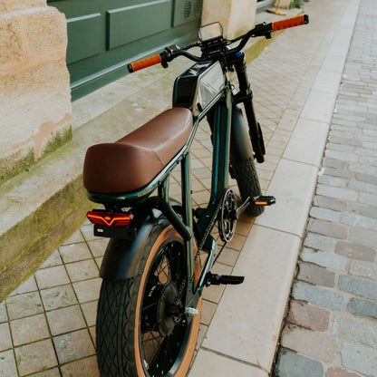 Arrière du fatbike électrique 2 places City S Unikride avec selle biplace, feu arrière et guidon orange.