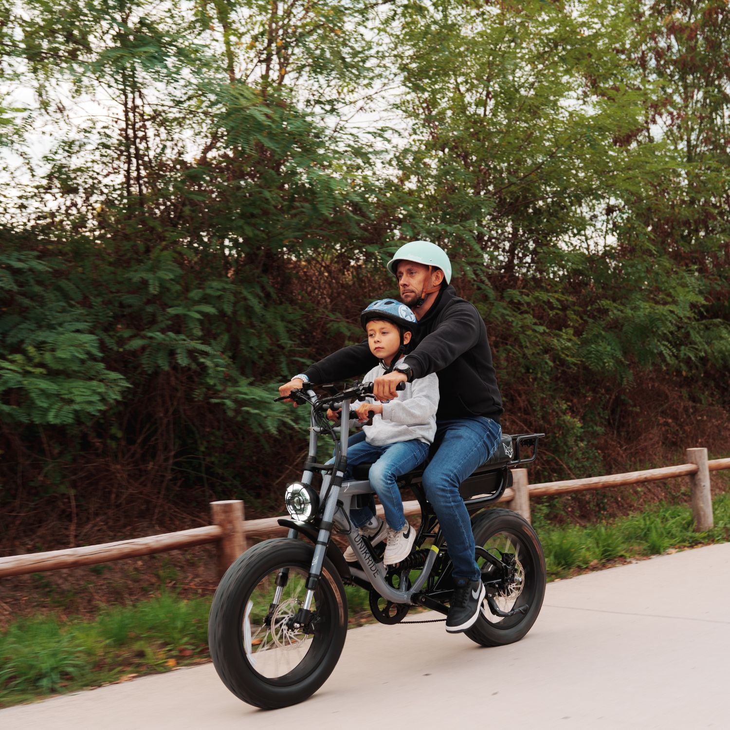 Parent et enfant en balade sur vélo électrique équipé d un kit selle de cadre pour enfant